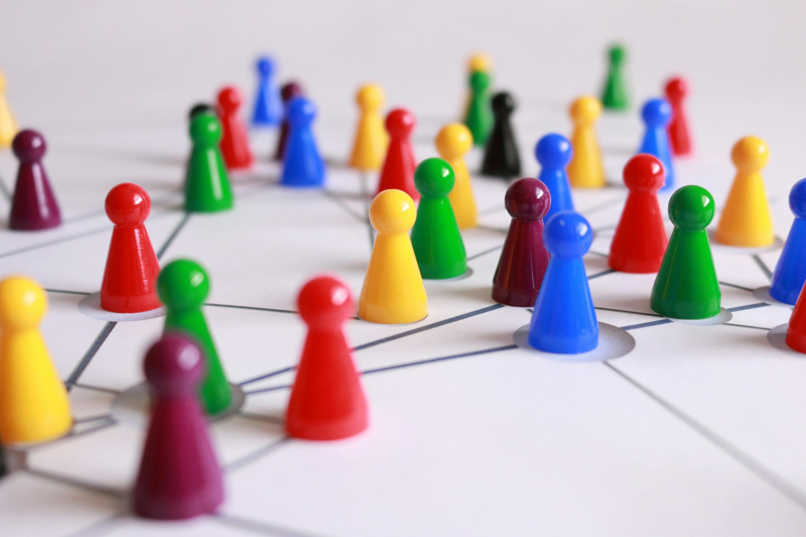 Close Up Photography of Yellow Green Red and Brown Plastic Cones on White Lined Surface