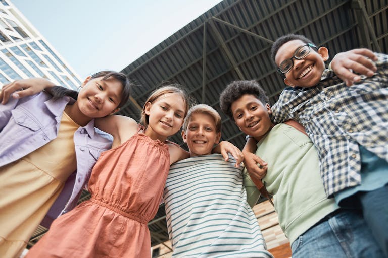 Kids Arms Around Each Other while Smiling at the Camera